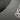 Close-up of a dark gray textured athletic surface with a black curved trim and a partial white geometric logo.