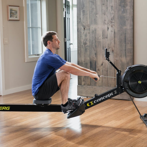 Load image into Gallery viewer, concept2 rowerg tall legs side view with man
